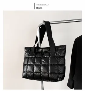 Detail of black quilted tote bag with shiny puffer fabric and sturdy woven handles