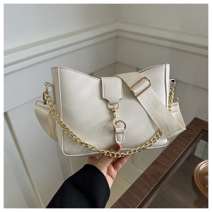 Detalle del bolso bandolera blanco con cadena dorada y correa de tejido ajustable