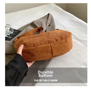 Macro view of the durable corduroy bag bottom featuring reinforced stitching detail