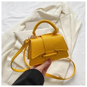 Detailansicht der leuchtend gelben Mini-Ledertasche mit Lychee-Muster und Umhängeriemen