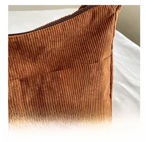Macro detail of caramel corduroy bag fabric with SPORT leather patch and zip