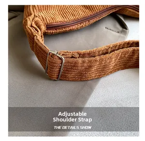 Detail of adjustable shoulder strap on brown corduroy bag with silver metal buckle