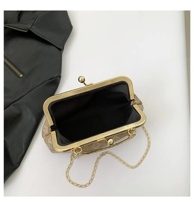 Detalle de bolso clutch de jacquard beige con cierre dorado y correa de cadena