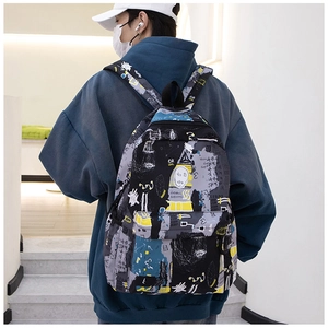 Rear view of a street style graffiti backpack featuring multiple zipper pockets on a model
