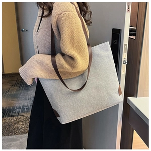 Linen texture tote bag detail showing large capacity and brown leather shoulder straps