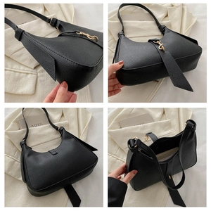 Detailansicht der schwarzen Schultertasche aus genarbtem Leder mit goldener Hardware