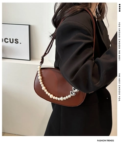 Brown leather crossbody bag with decorative white pearl chain and silver heart pendants