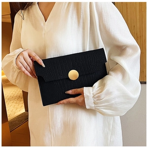 Close-up of black envelope clutch featuring crocodile texture and a gold metal buckle
