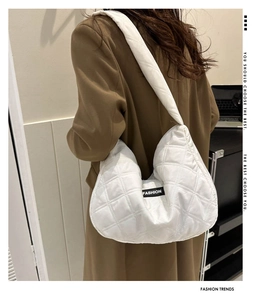 Détail d'un sac à bandoulière matelassé blanc avec étiquette logo FASHION moderne
