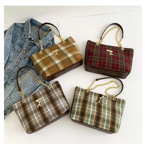 Plaid wool tote bag detail showing check pattern, gold deer pendant and chain strap