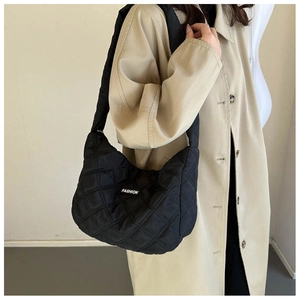 Détail du sac à bandoulière matelassé noir avec étiquette logo de mode sur tissu nylon