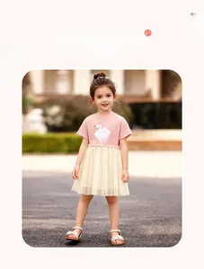 Détail de la robe pour fille avec haut rose à motif cygne et jupe en tulle beige doux