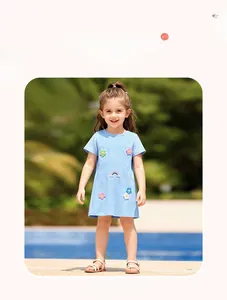Detail of girl's blue short sleeve dress with floral patches in an outdoor setting