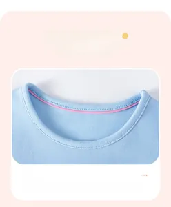 Close-up of girls blue cotton knit dress showing round neckline and pink piping detail