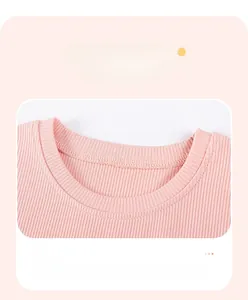 Détail de robe rose pour fille montrant la maille côtelée et l'encolure ronde