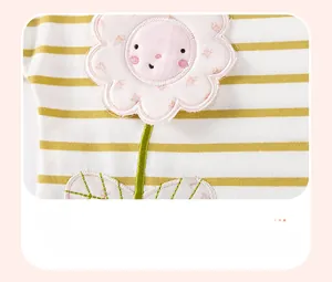 Detail of baby girl stripe knit top featuring a pink flower applique with fine embroidery