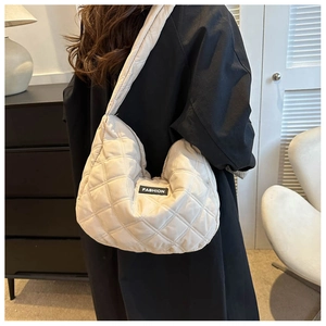 Gros plan du sac bandoulière beige matelassé avec étiquette de mode et coutures premium