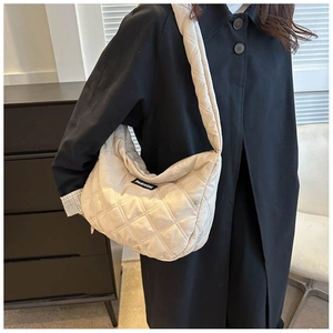Détail du sac à bandoulière matelassé beige avec étiquette mode et texture moelleuse