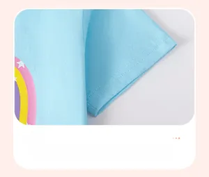 Détail des coutures sur la manche courte et motif arc-en-ciel sur le T-shirt en coton bleu enfant