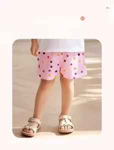 Détail d'un short d'été en coton rose pour fille avec des pois colorés