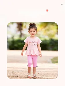 Detail of girls' summer set with pink ruffled t-shirt and cropped pants set