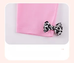Detail of pink cotton leggings with a stylish leopard print bow and neat hem stitching