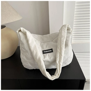 Détail de la texture d'un sac cabas rembourré blanc avec écusson de mode minimaliste