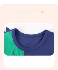 Detail of baby boy cotton t-shirt neckline with dinosaur spike and durable stitching