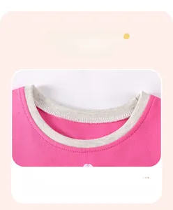 Détail de la robe tricotée rose montrant le col contrasté gris et les finitions