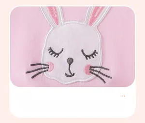 Close-up of pink girls dress showing exquisite cartoon rabbit embroidery and applique detail
