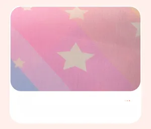 Close-up of pink and blue gradient cotton fabric with white star patterns for girls