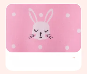 Detail of pink cotton dress featuring white polka dots and a cute cartoon rabbit print