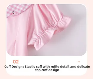 Détail d'une robe en coton rose avec col vichy à motif cerise et poignets élastiques volantés