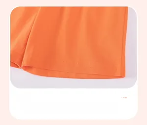 Gros plan du short en coton orange avec coutures à double aiguille et bords plats