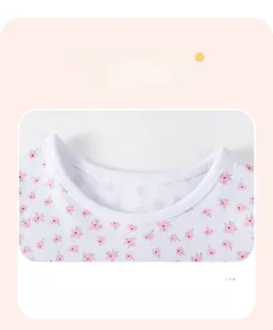 Detail of baby girl cotton dress neckline with pink floral print and piped collar