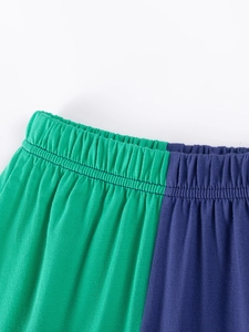 Kids cotton shorts featuring green and navy blue colorblock design with elastic waistband