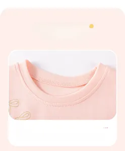 Close-up of the reinforced crew neck and soft cotton texture on a pink girls' summer dress