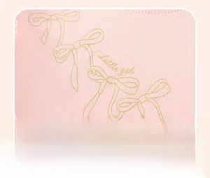 Close-up of pink cotton fabric with gold glitter Little Girl lettering and bows