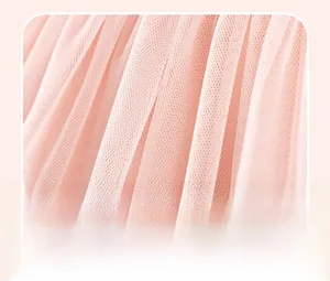Close-up of pink mesh tulle fabric with delicate pleated texture on a girl dress