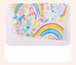 Detailed view of white knitted baby pants with vibrant floral and rainbow print patterns