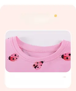 Détail du col d'un t-shirt en coton rose avec motif de coccinelle et coutures plates
