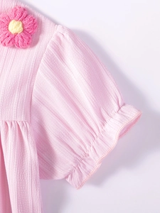 Short sleeve girls pink dress with textured pleated fabric and crochet flower detail