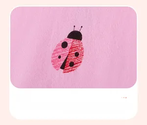 Détail du tissu en coton rose avec d'adorables motifs de coccinelles imprimés