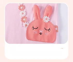 Gros plan sur tissu en coton rose avec patch lapin mignon et broderie de fleurs marguerites