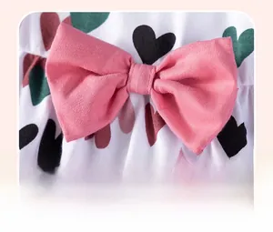 Close-up of pink 3D cotton bow and colorful heart prints on summer baby girl dress