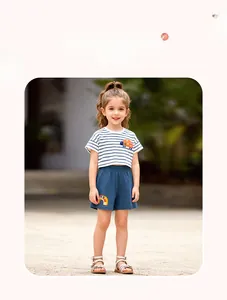 Détail de l'ensemble fille en coton avec t-shirt rayé coccinelle et short bleu