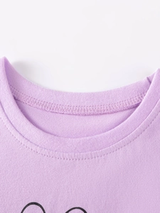 Gros plan du col de t-shirt en tricot violet avec bord-côte durable et finitions soignées