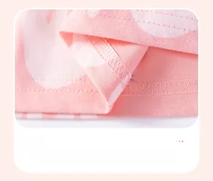 Détail de l'ourlet à double couture sur robe en coton rose avec motif à pois blancs