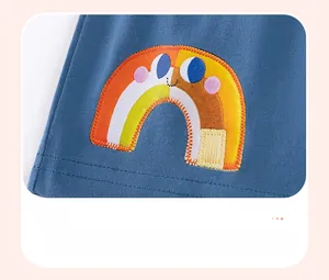 Détail de la broderie arc-en-ciel multicolore sur tenue tricotée rayée pour filles