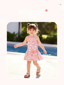 Detail showing colorful floral pattern and bow on a pink summer dress for girls